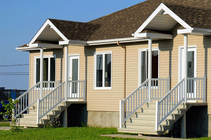 A picturesque duplex sits against a clear blue sky.