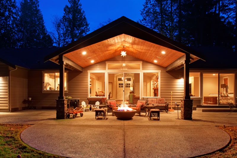 An entryway to a beautiful home is illuminated with soft warm lights at night.