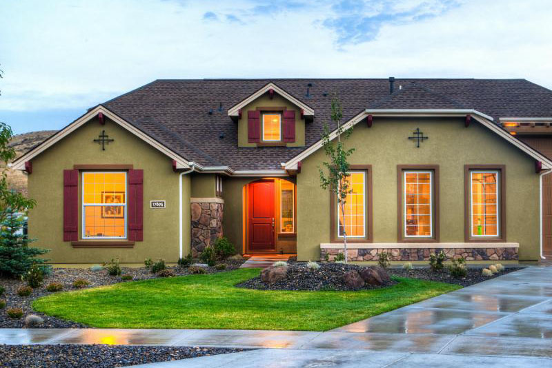 A beautiful single-family home with olive green siding and red accents.